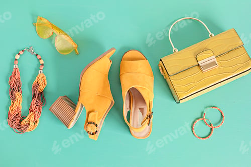 Preview: Flat lay with woman fashion accessories in yellow color over turquoise background. Fashion, online