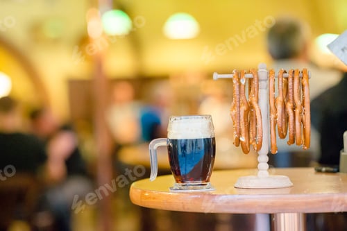 Preview: Close up salted tasty pretzels and beer on wooden background