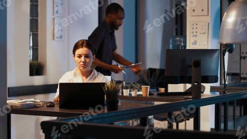Preview: Manager using e commerce and sales data on laptop at night