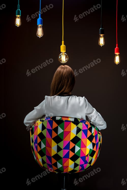Preview: Woman sitting on the chair with illuminated colorful lamps