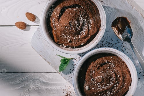 Preview: top view of bowls with chocolate dessert on wooden board on table