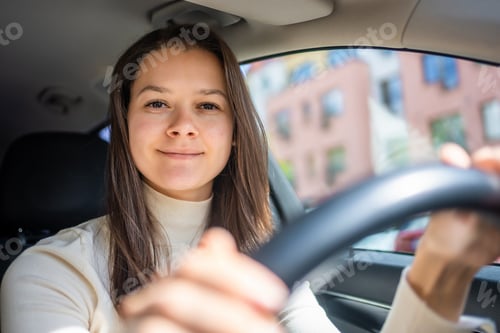 Preview: Happy woman driving a car and smiling. Cute young success happy brunette woman is driving a car