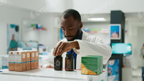 Preview: Male specialist putting stock of medicaments and drugs