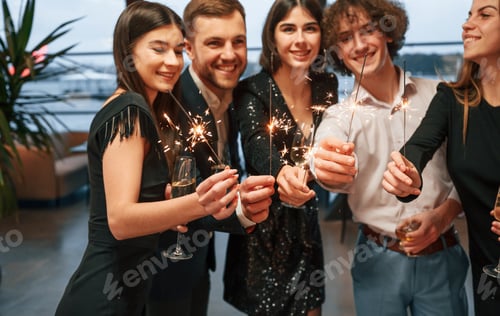 Visualização: Grupo de pessoas com lindas roupas elegantes estão comemorando o Ano Novo em ambientes fechados juntos