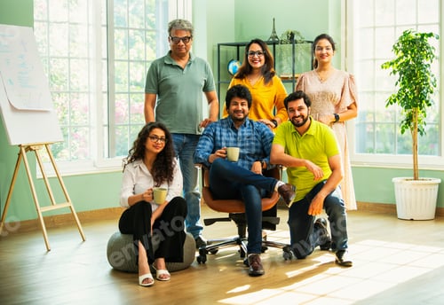 Preview: Confident Indian Asian business team in casuals, smiling, celebrating success in modern workspace
