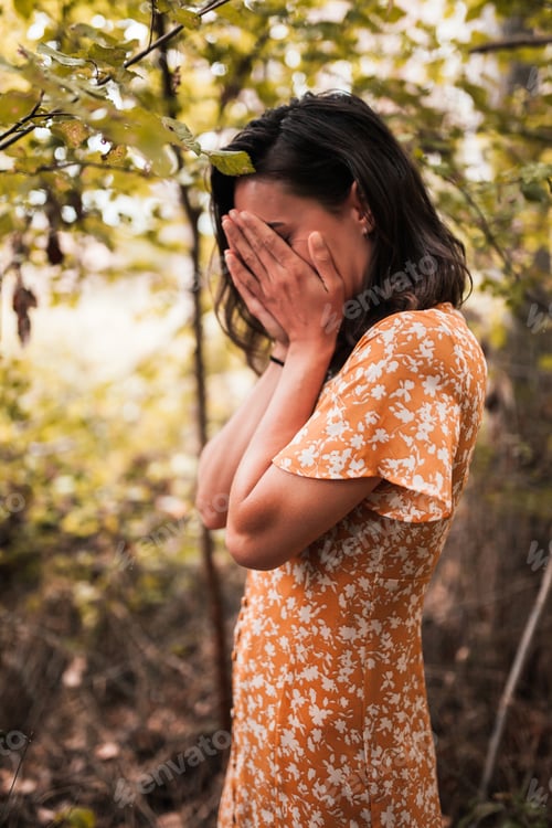 Preview: Outdoor portrait of a beautiful brunette woman wearing a dress in the forest