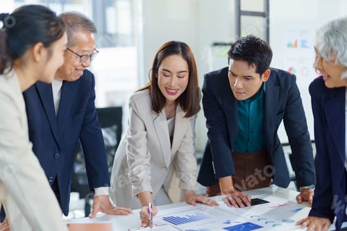 Preview: Asian businesspeople analyzing financial charts during a meeting