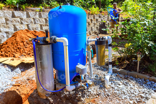 Preview: Water filtration system installation in residential garden during sunny afternoon