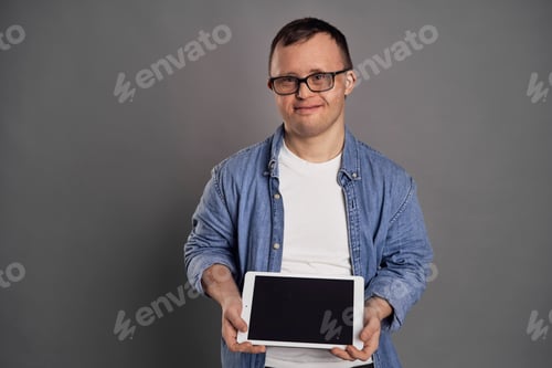 Preview: Caucasian man with down syndrome showing screen on tablet