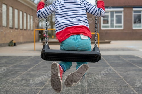 Preview: Boy swinging on a public park swing