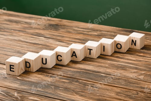 Preview: wooden blocks with letters on wooden surface on green