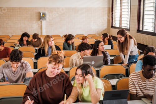 Preview: Teacher explaining to students individually while they do work. focus on teacher