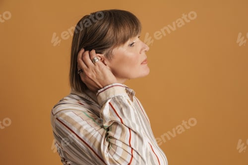 Preview: Senior woman wearing striped shirt posing and looking aside