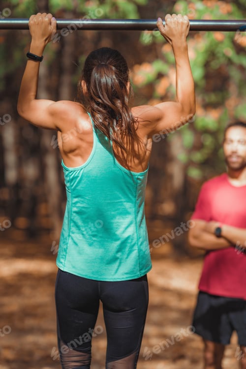 Preview: Woman doing pull-ups in the park