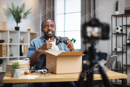 Preview: Man recording video while unpacking box with joystick