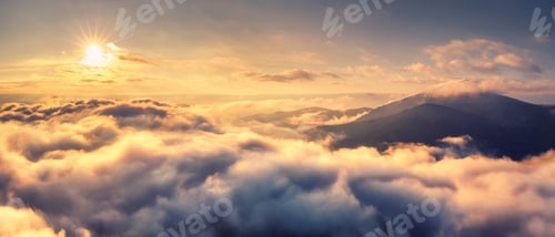 Preview: Aerial view of mountains in orange clouds at sunrise in summer