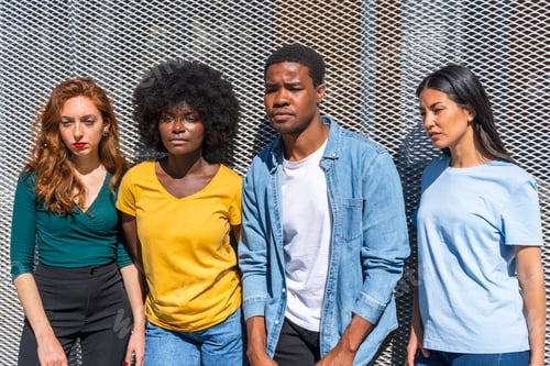Preview: Happy multiethnic friends in the city on a gray wall, young models