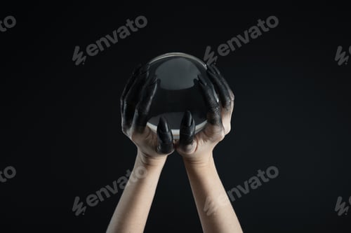 Preview: Cropped view of witch hands in black dye holding crystal ball isolated on black