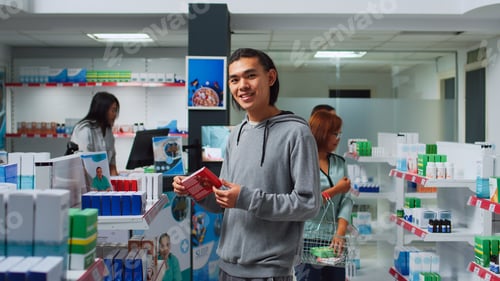 Preview: Asian customer checking pills boxes on pharmacy shelves