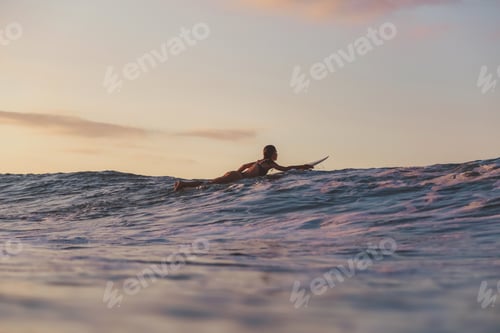 Preview: woman on surf board floating on water