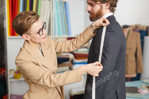 Preview: Woman Tailor Measures Man for Bespoke Suit