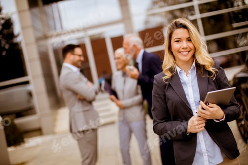 Visualização: Jovem empresária em pé ao ar livre enquanto outras pessoas falando no fundo