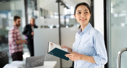 Preview: Young happy business woman holding notebook in corporate office