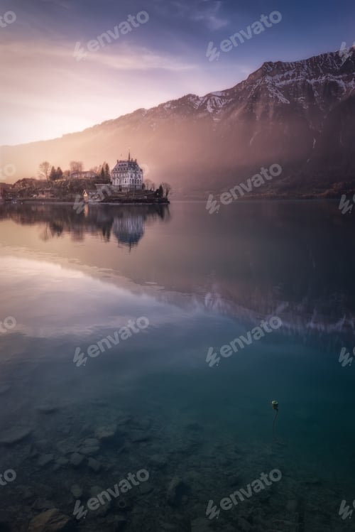 Preview: Tranquil lake with boats on pier and resort against mountains