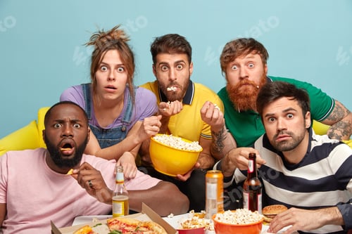 Preview: Astonished best friends watch horror film at home, stare with eyes popped out, eat popcorn, drink co
