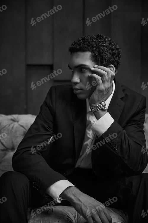 Preview: black and white photo of attractive young african american man in chic suit sitting and looking away