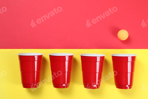 Preview: Plastic cups and ball on color background, flat lay with space for text. Beer pong game