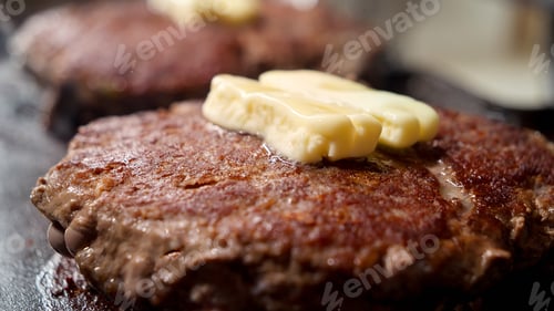 Preview: Closeup of butter melting on cooking beef burger patties on grill. Cooking at home