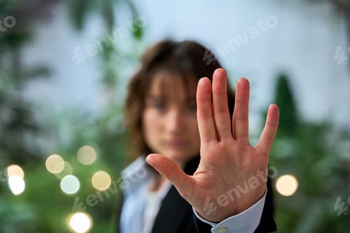 Preview: Businesswoman making stop sign with hand in office