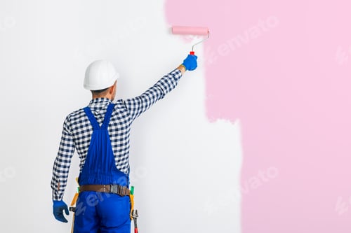 Preview: Rear view of painter man painting the wall in pink
