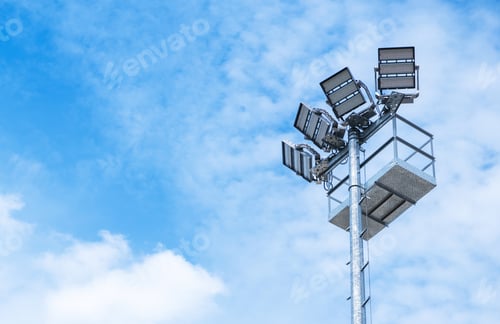 Preview: Bright Lighting Tower Stands Tall Against a Clear Blue Sky During the Day at an Outdoor Venue