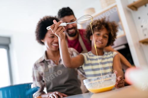 Preview: Happy african american family preparing healthy food in kitchen, having fun together on weekend