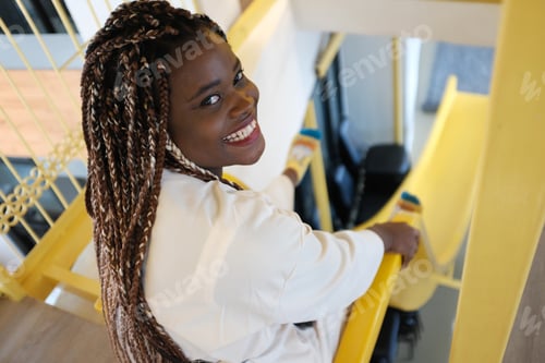 Preview: Portrait of a young black woman, afro hairstyle, in urban background