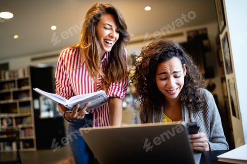 Preview: Group of happy students reading books and preparing to exam in library