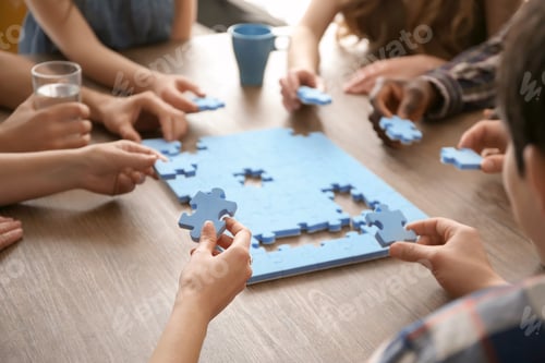 Preview: People with puzzle at table, closeup of hands. Unity concept
