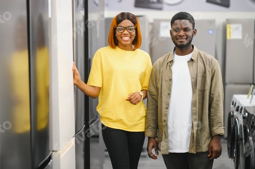 Preview: African american family couple buying domestic refrigerator in supermarket