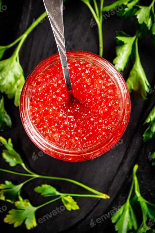 Preview: Red caviar in a glass jar with a spoon.
