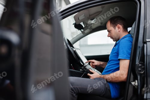 Man Diagnosing Car Issue with Computer System