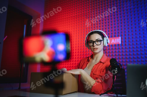 Preview: A young blogger girl records a video and unpacks a box with goods from an online store