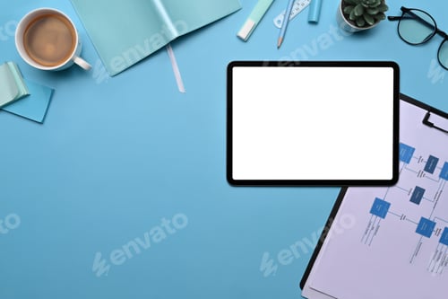 Preview: Top view digital tablet, supplies and financial documents on blue background.