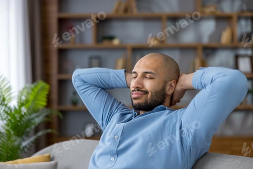 Preview: Young man relaxing with closed eyes on sofa