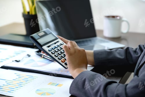 Preview: Businesswomen hand use calculator analysis the graph for Setting challenging business goals