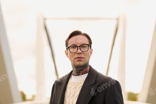 Preview: Handsome stylish man with tattoos showcasing modern fashion against a striking urban backdrop
