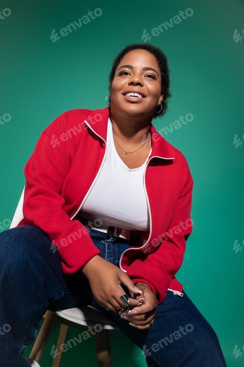 Preview: Stylish plus size african american woman showcases trendy autumn outfit in studio