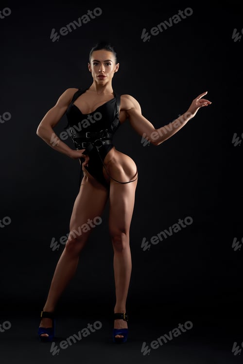 Preview: Muscular, attractive woman standing, posing in studio.