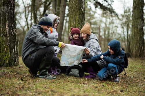 Preview: Family and kids with map in the forest.